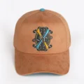 Opus X Society Earth snapback hat, front view in tan suede with the Opus X Society crest patch