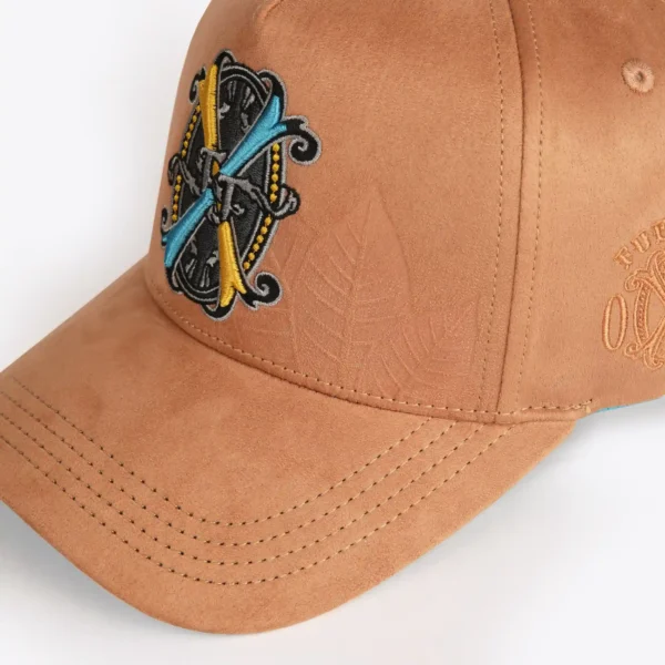 Opus X Society Snapback Hat Suede Earth Limited Edition 5 Opus X Society Earth snapback hat, angled front view with a debossed tobacco leaf beside the crest