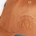 Close up of the debossed Fuente OXS monogram on the side of the Earth snapback hat