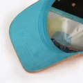 Teal underbrim and printed satin lining of the Opus X Society Earth snapback hat