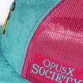 Close up of the magenta Opus X Society side patch with teal lettering
