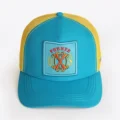 Opus X Society teal and yellow trucker hat, front view with the Fuente OXS crest patch