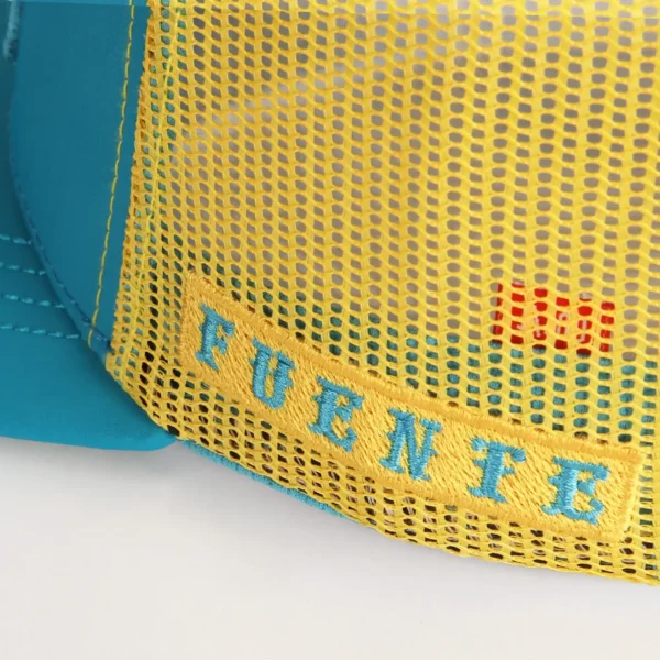 Opus X Society Trucker Hat Teal and Yellow Limited Edition 6 Close up of Fuente embroidered on the yellow mesh of the Opus X Society trucker hat